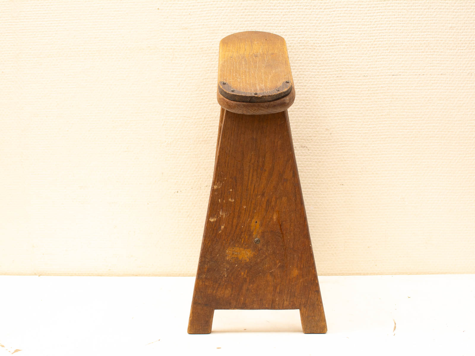 Rustic wooden stool with triangular base, rich oak finish, and vintage charm for cozy spaces.