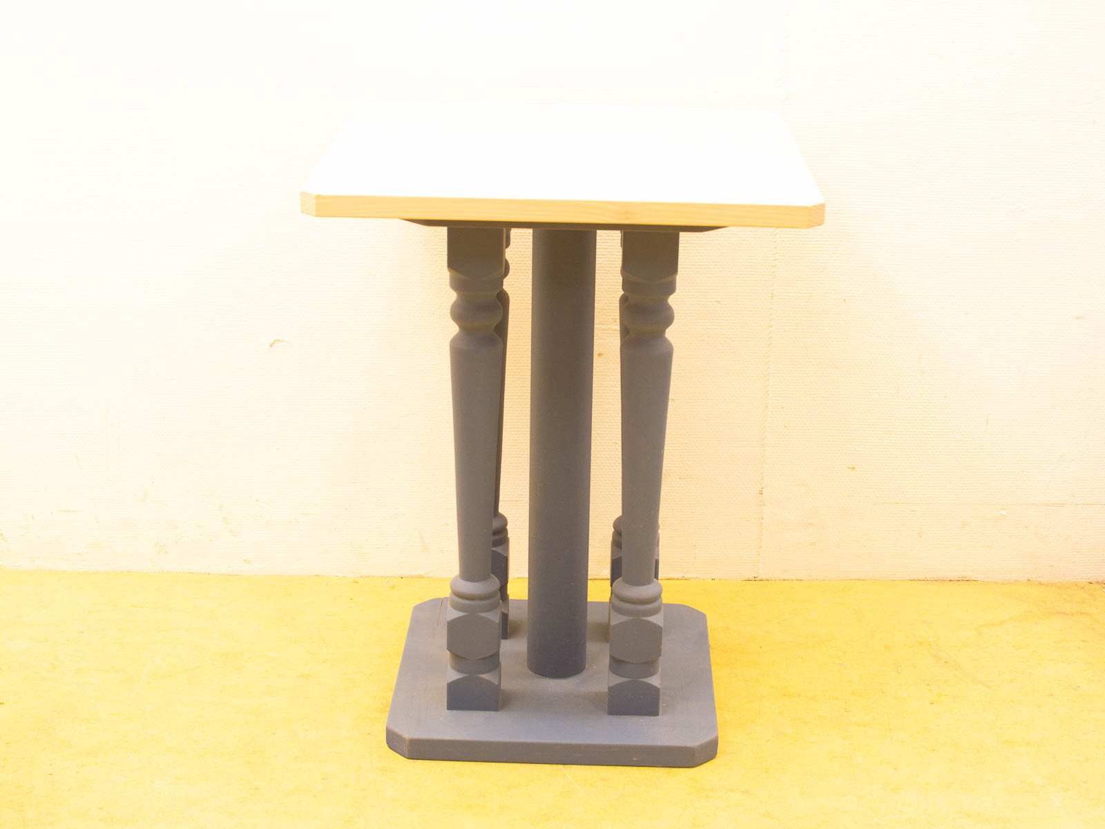 Elegant minimalist wooden table with rounded edges and dark gray turned legs, versatile for any decor.