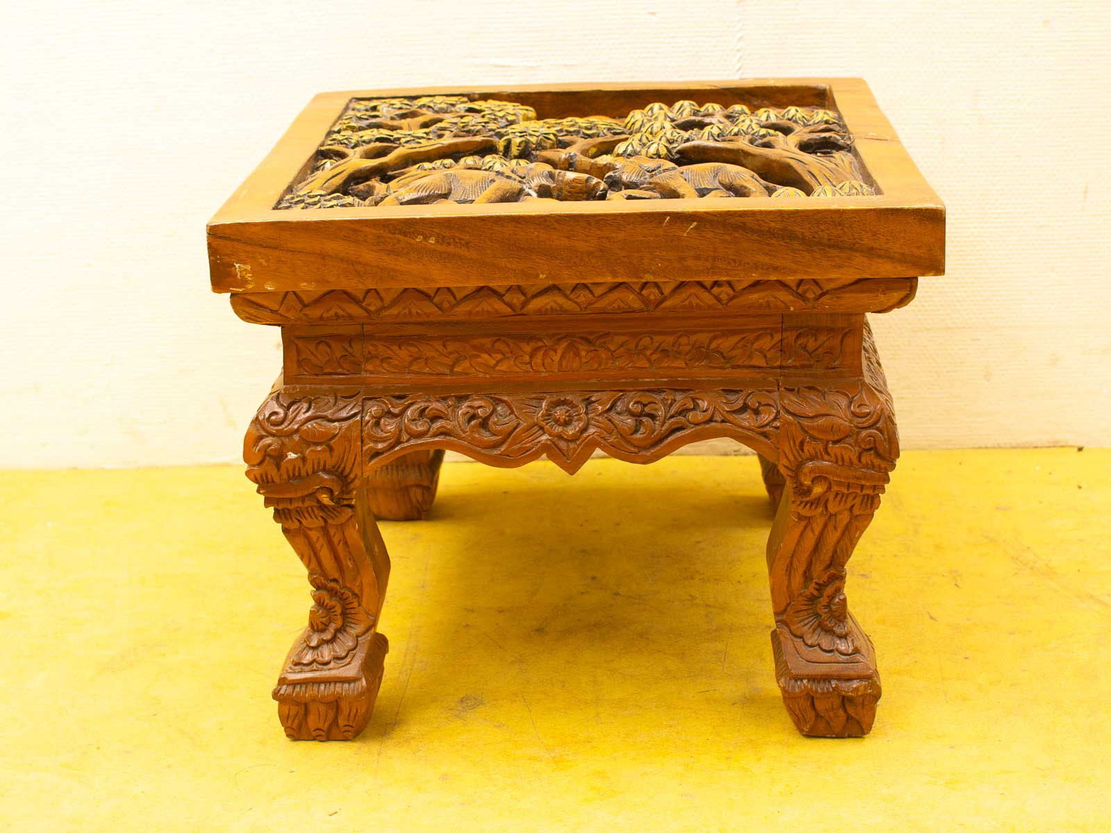 Elegant wooden table with intricate carvings and natural motifs, showcasing exquisite craftsmanship.