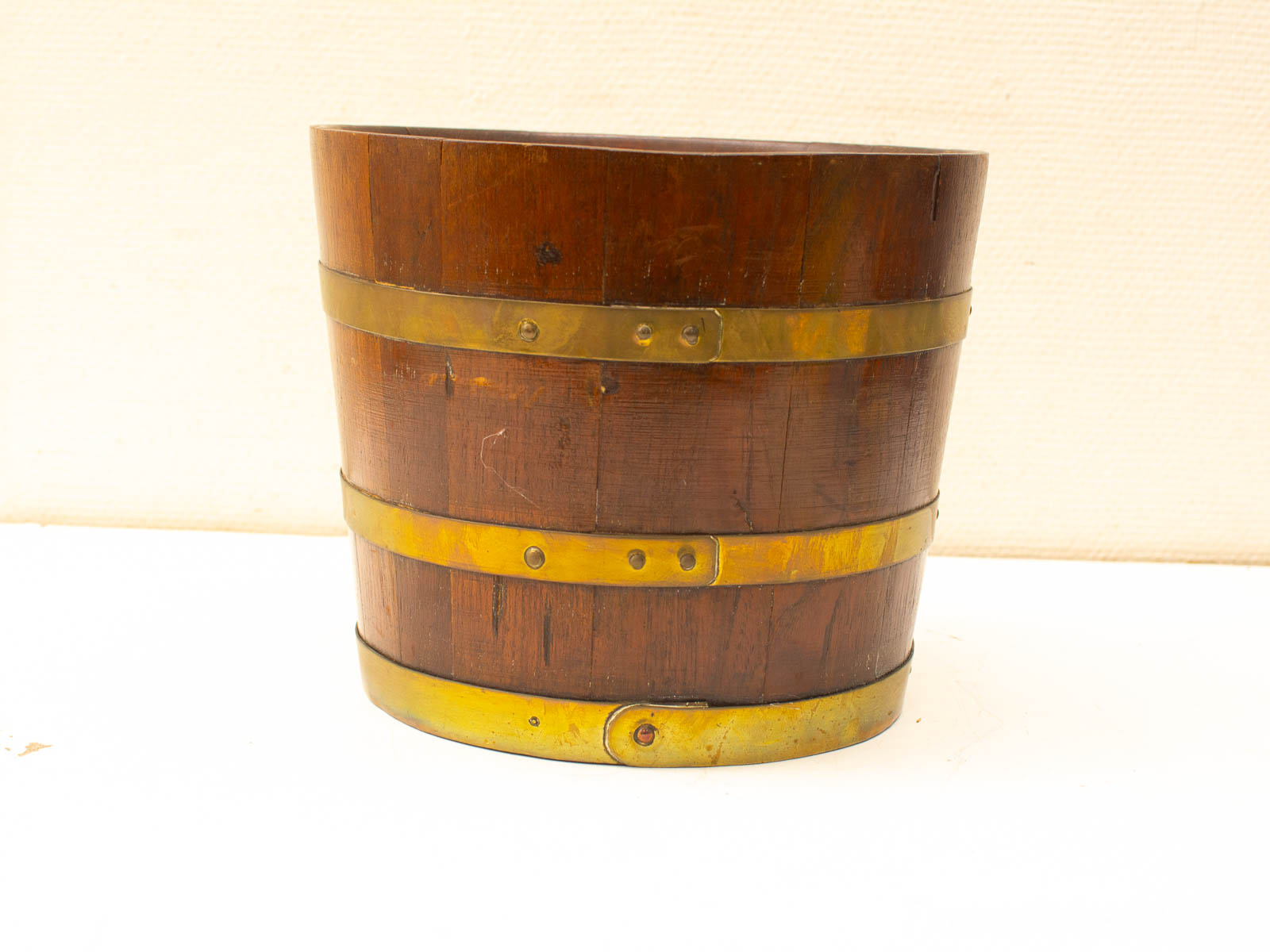 Vintage wooden bucket with brass bands, perfect for decor or storage in any home.