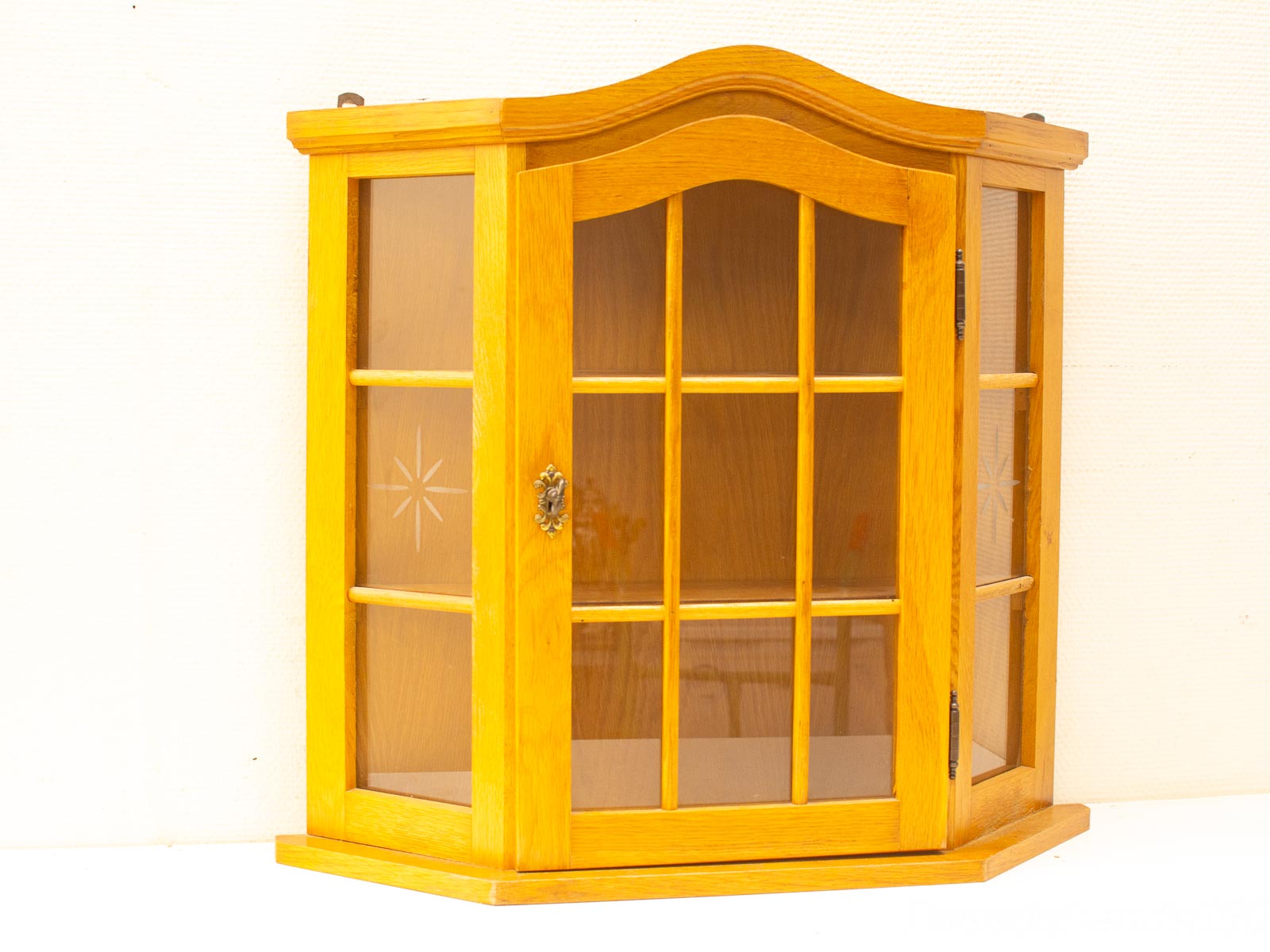 Elegant wooden corner cabinet with glass doors, perfect for showcasing treasures in style.