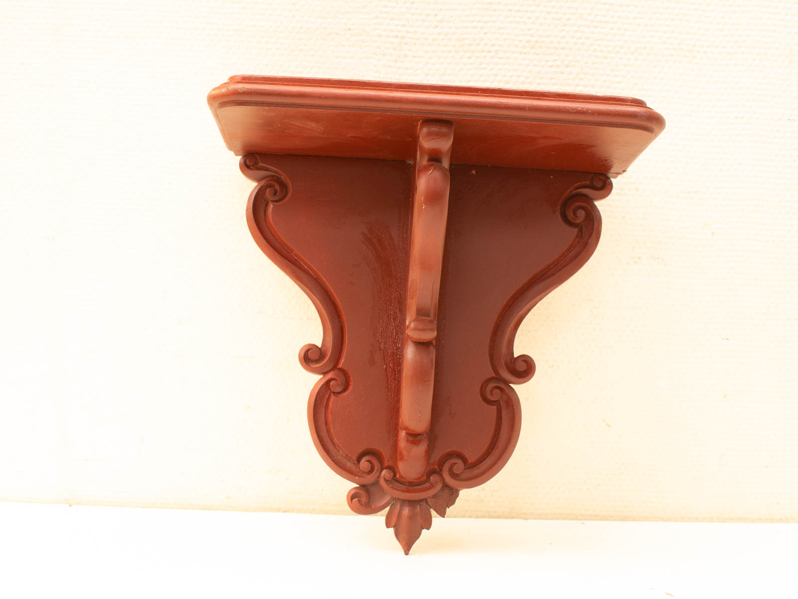 Elegant wooden wall shelf with intricate scrollwork, perfect for decorative displays and functional decor.