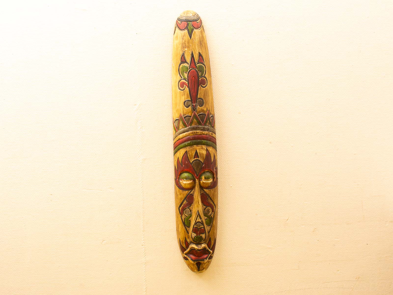 Vibrant wooden mask with intricate patterns, showcasing rich cultural heritage and artistic craftsmanship.