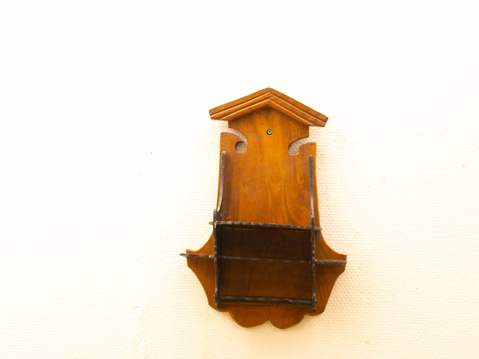 Charming vintage wooden wall shelf with elegant cutouts and rich brown tones for timeless decor.