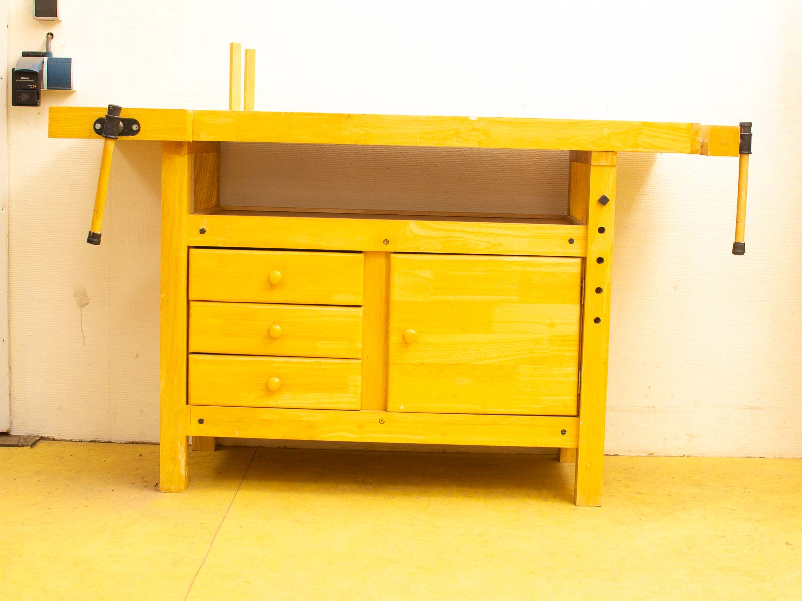 Bright yellow workbench with drawers and clamp, perfect for DIY and creative projects.