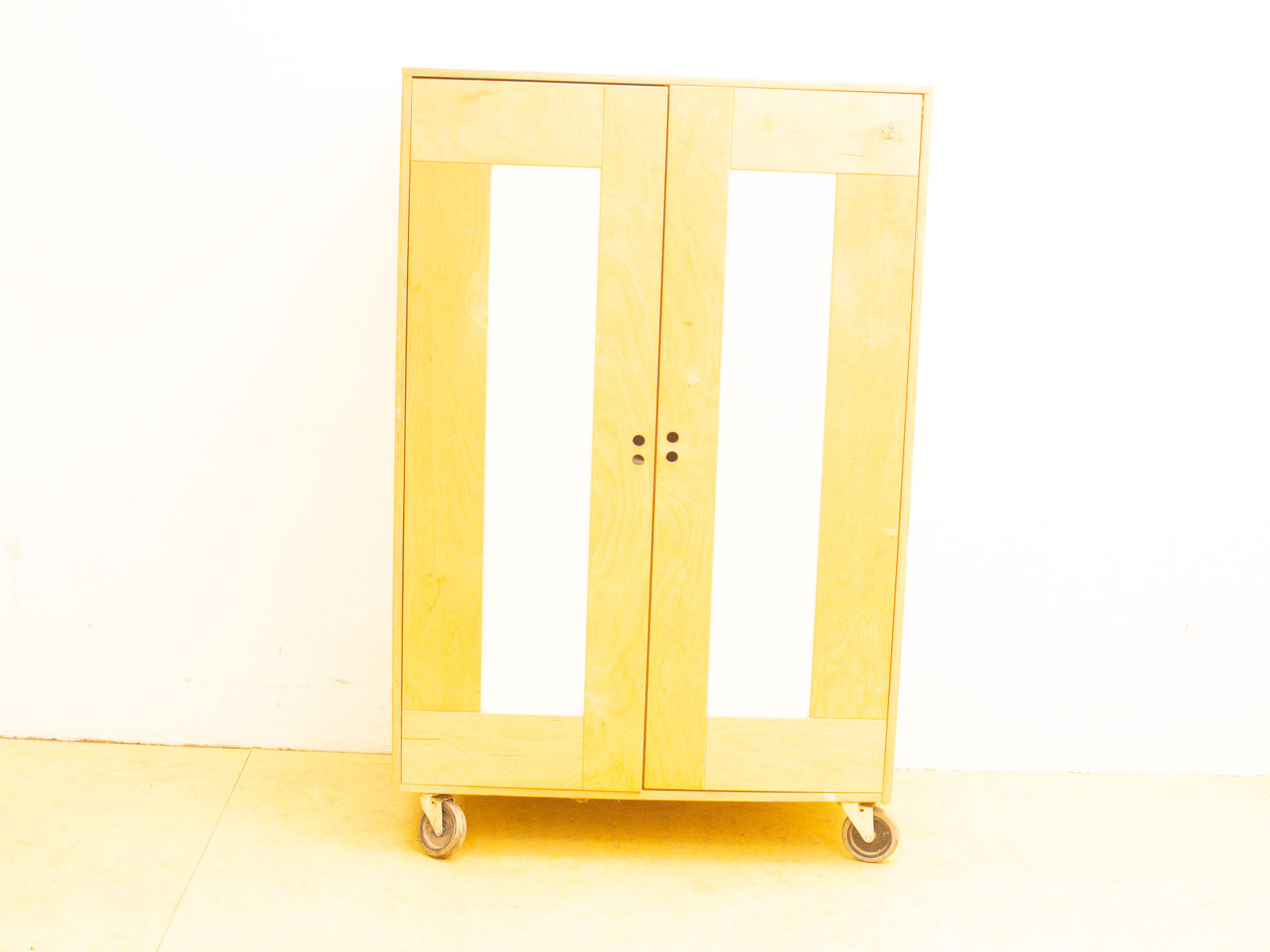 Modern light wood cabinet with wheels, minimalist design, perfect for any interior space.