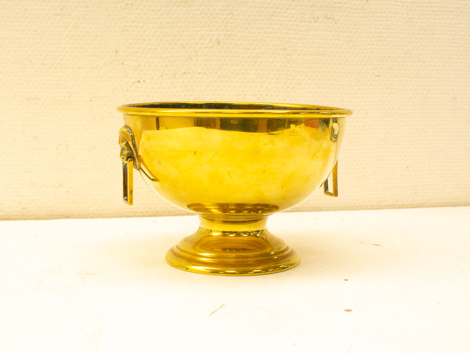 Elegant vintage gold bowl with mythical creature handles, showcasing exquisite craftsmanship and luxury.