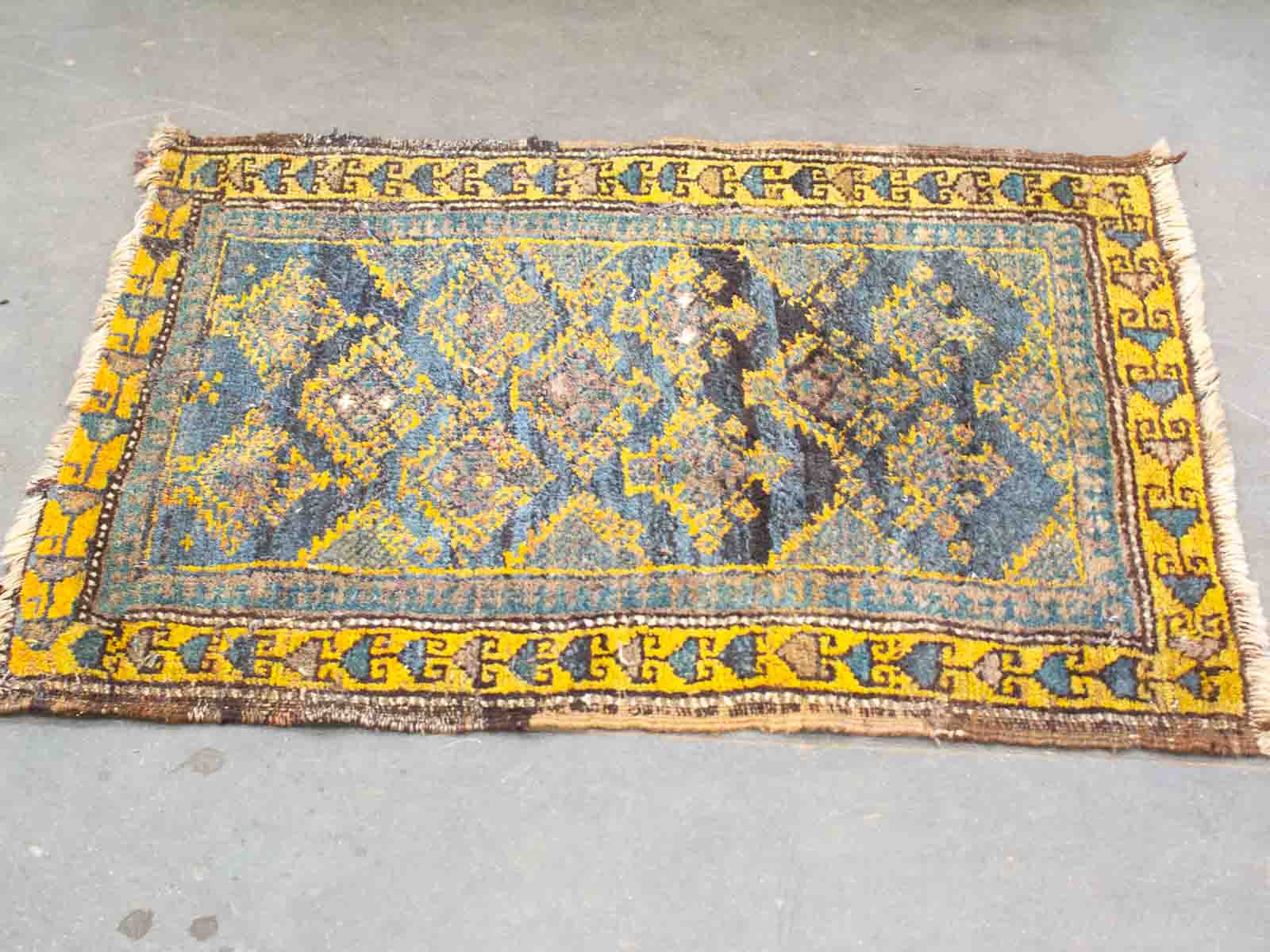 Vibrant vintage rug with intricate geometric patterns in deep blues, oranges, and yellows.