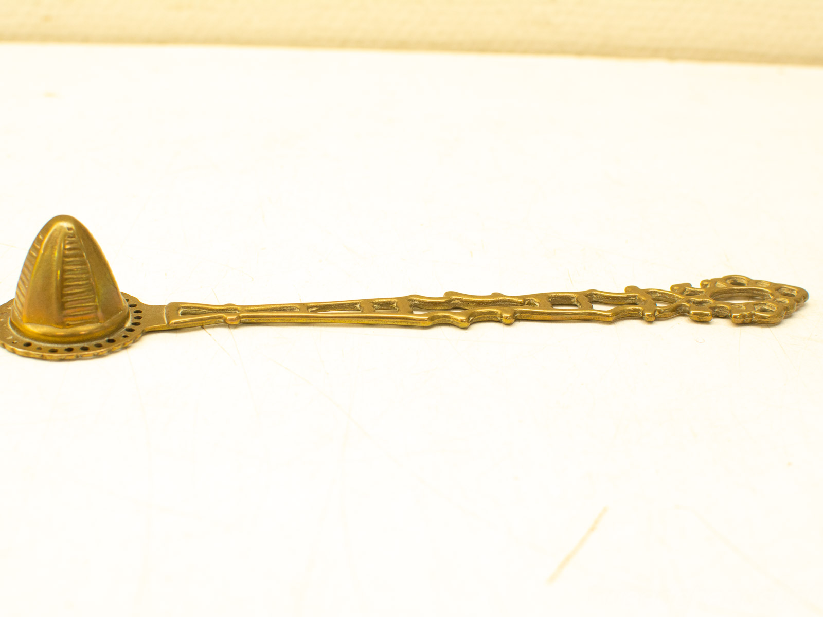 Ornate vintage gold tea strainer, perfect for collectors and tea enthusiasts, blending elegance and function.