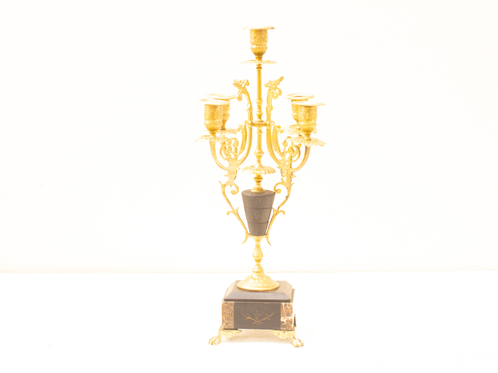 Elegant gold candelabrum with dark base, featuring intricate candle holders for luxurious ambiance.