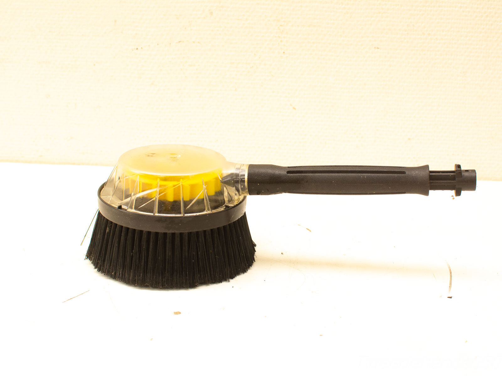 Ergonomic cleaning brush with transparent dome and durable bristles for effective dirt removal.