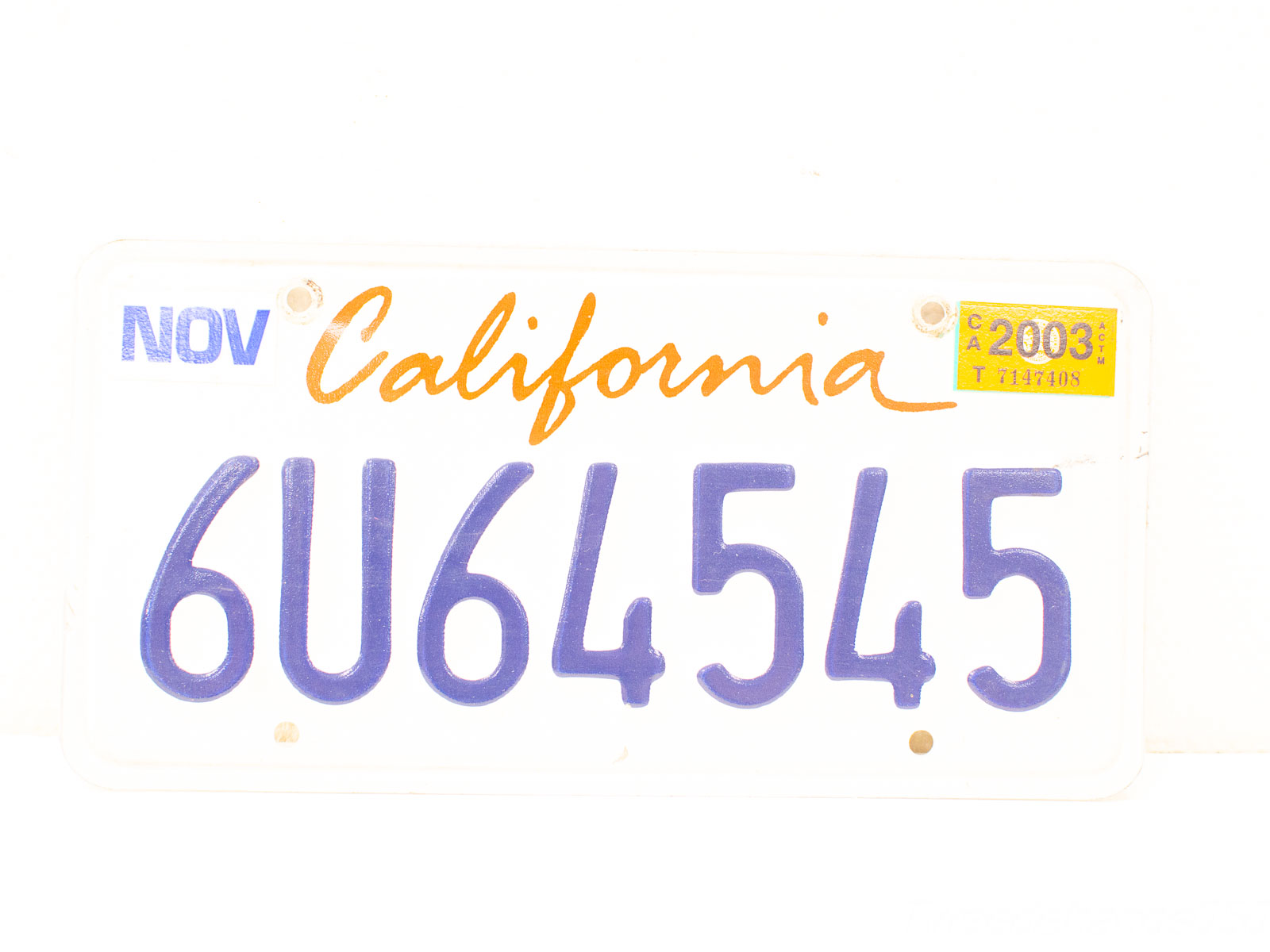 Vintage California license plate 2003, featuring unique code 6U64545 and stylish orange lettering.