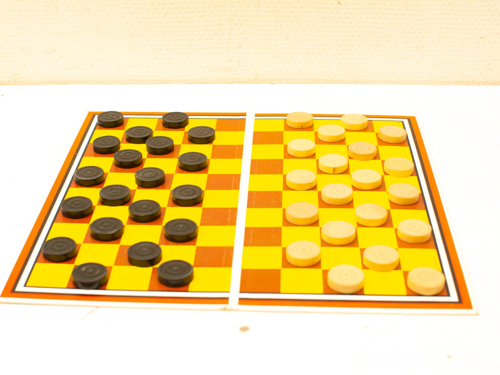 Vintage checkers board with polished black and textured light pieces, perfect for collectors.