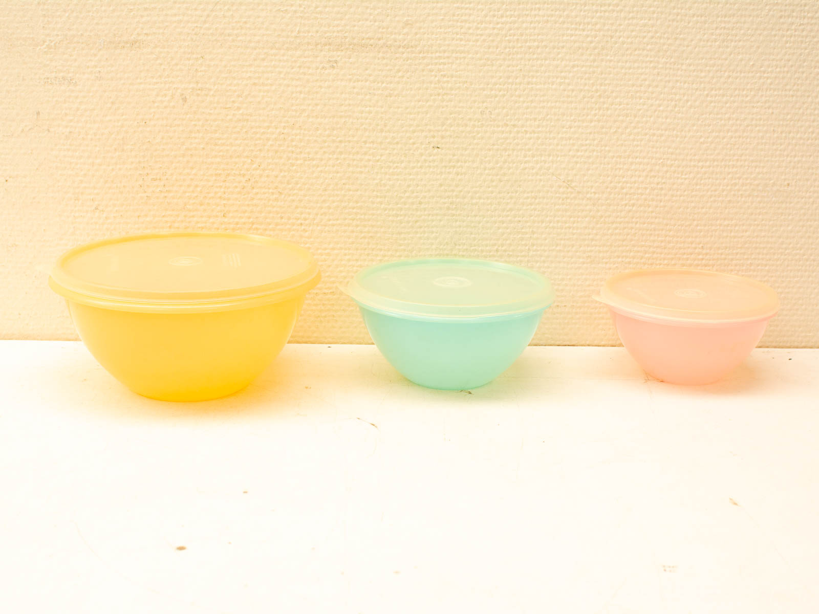 Vibrant vintage plastic bowls set: yellow, green, and pink for stylish storage and serving.