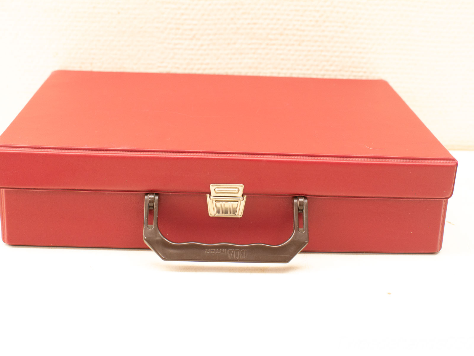 Durable red storage case with handle and latch, ideal for tools and personal items.