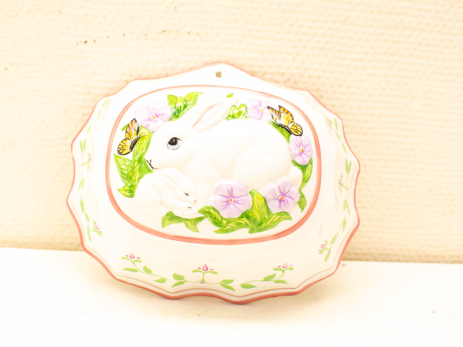 Charming white ceramic dish with rabbits and flowers, showcasing elegant craftsmanship and natures beauty.