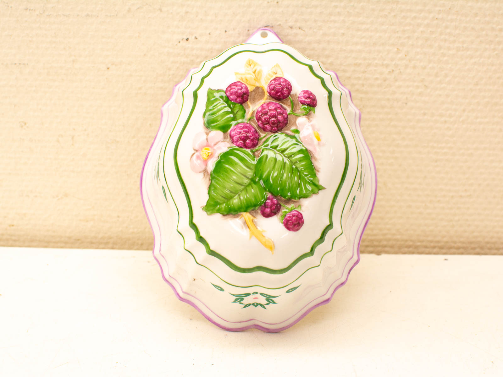 Elegant porcelain dish with raspberry design and floral accents, ideal for decorative display.