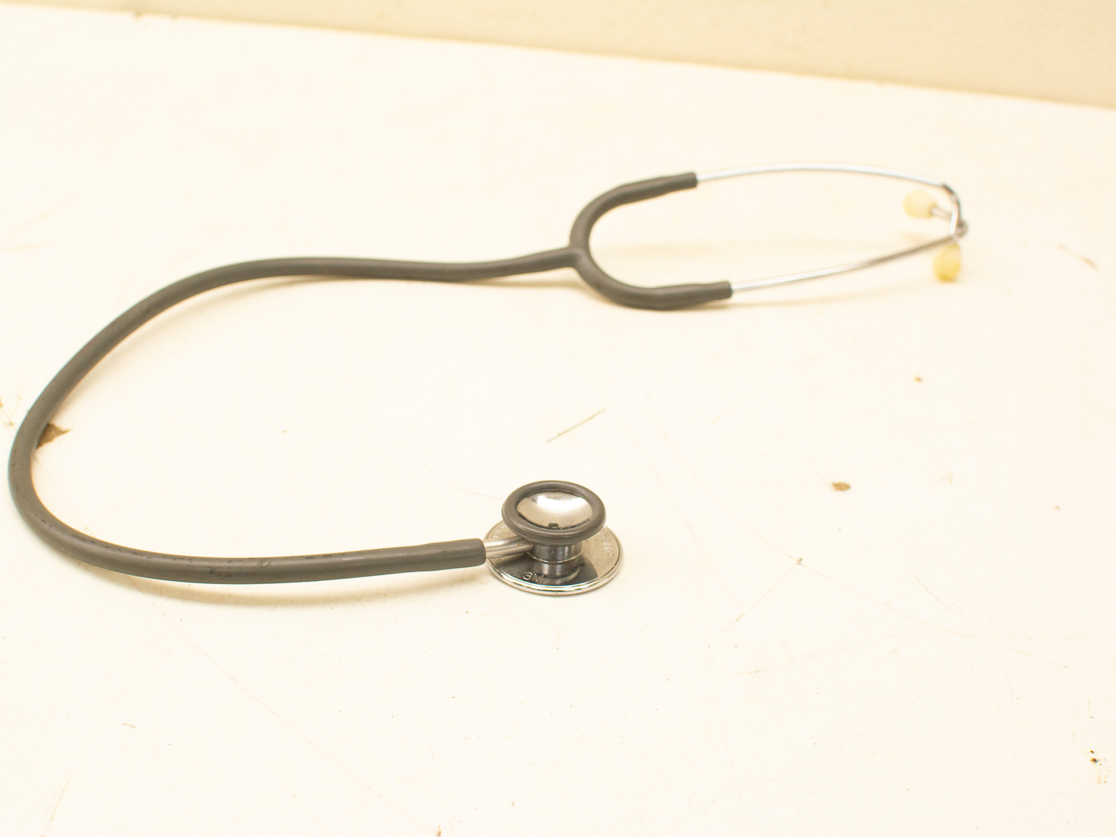 Sleek stethoscope on worn surface, symbolizing essential healthcare tools for patient diagnosis and care.