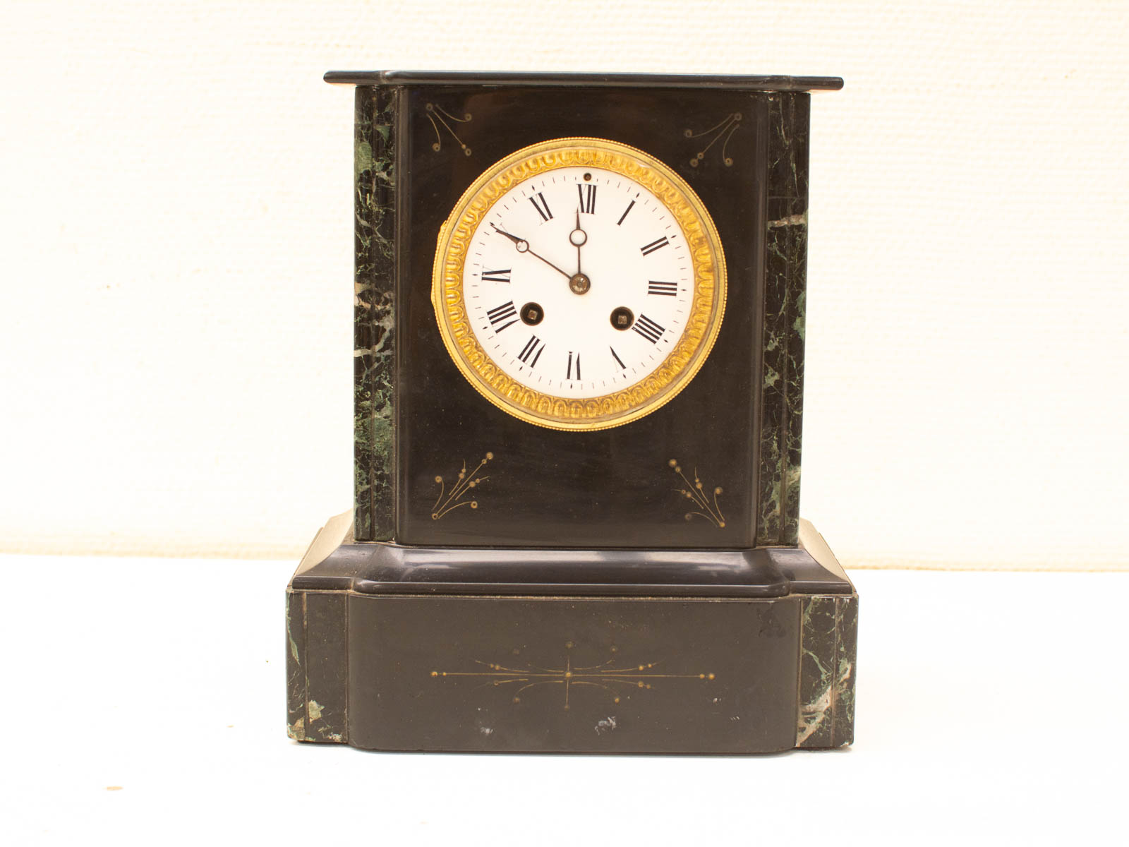 Elegant vintage mantel clock with black casing, white dial, and gold accents for timeless decor.