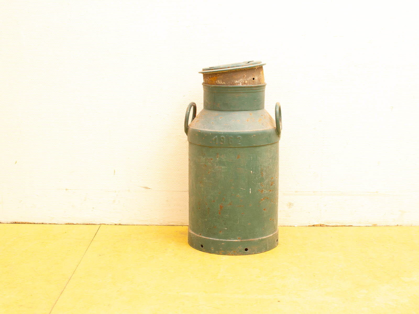 Rustic vintage green milk can with character, featuring handles and a convenient lid.