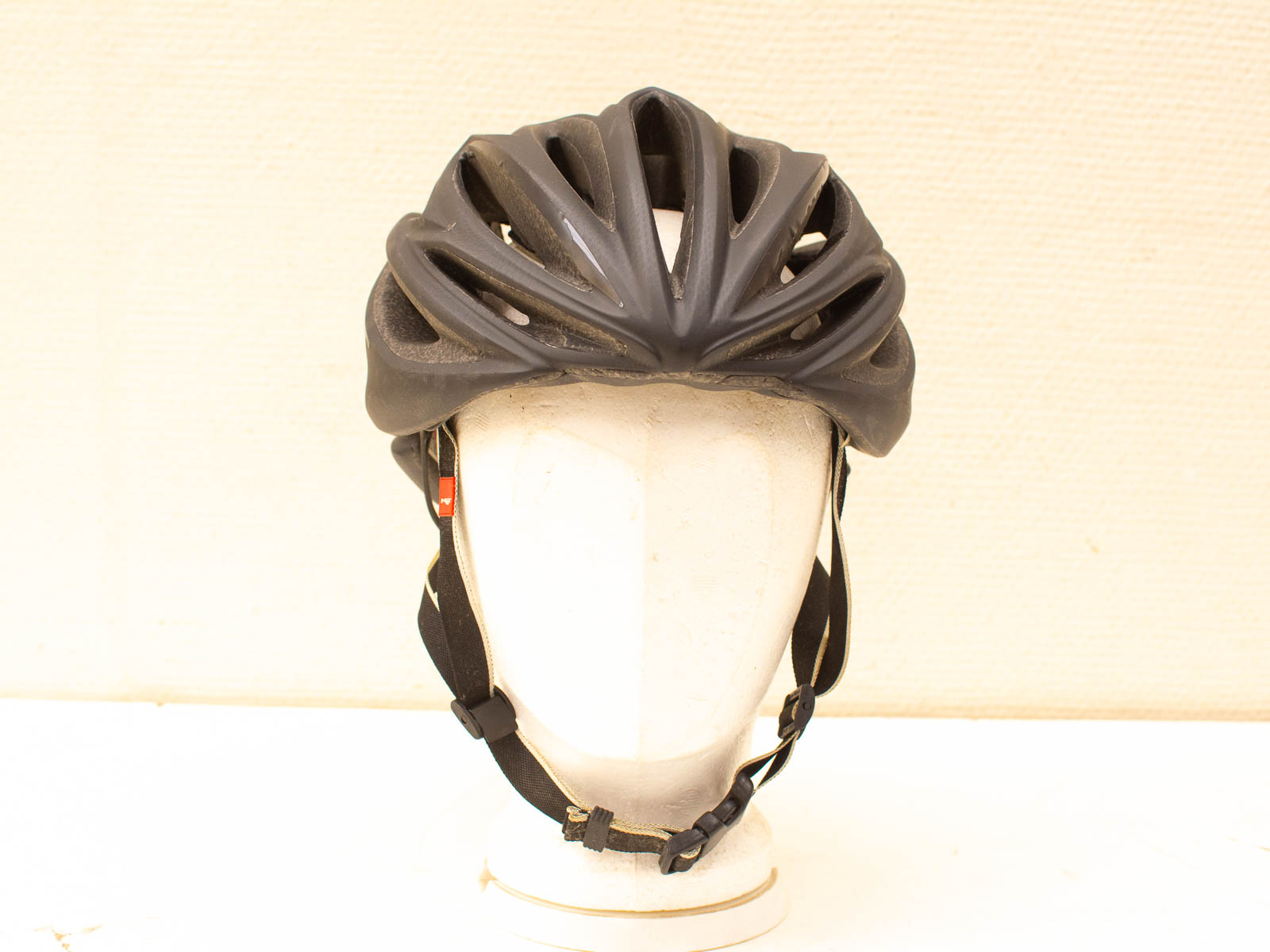 Sleek black aerodynamic bike helmet for stylish, safety-conscious cyclists with adjustable straps.