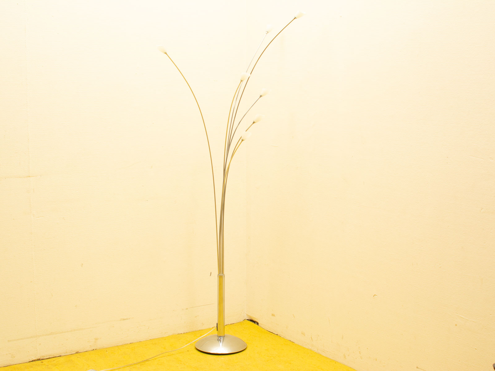 Modern floor lamp with flexible arms complements vibrant yellow carpet in stylish interior design.