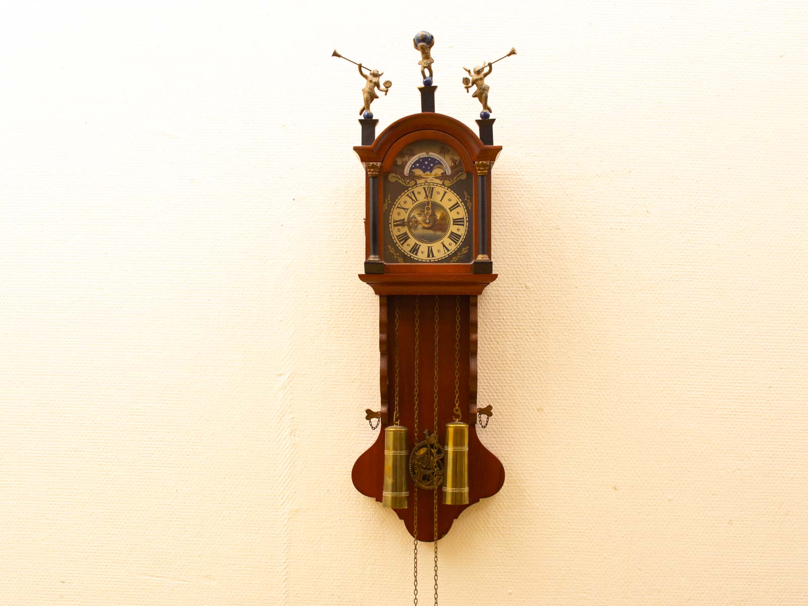 Elegant vintage wooden wall clock with Roman numerals and charming musician figures. Perfect for classic decor.