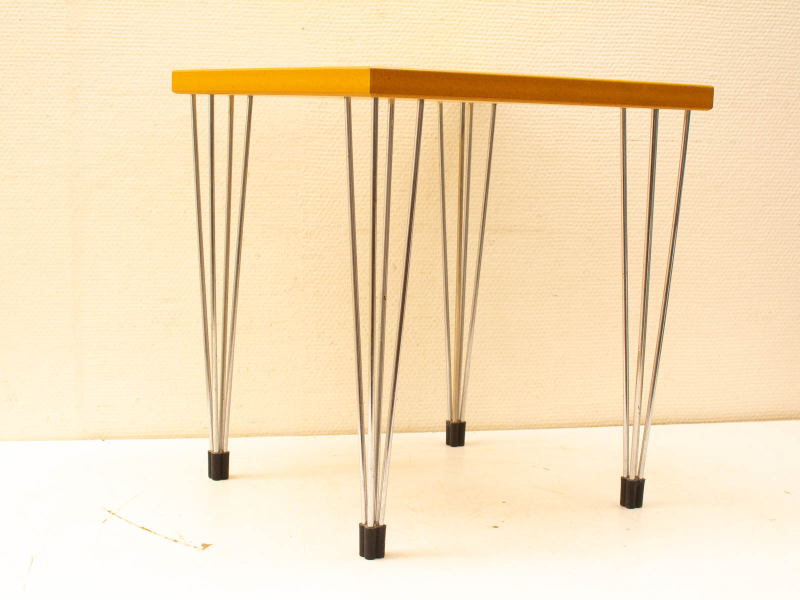 Sleek yellow table with chrome legs, perfect for modern interiors and versatile spaces.