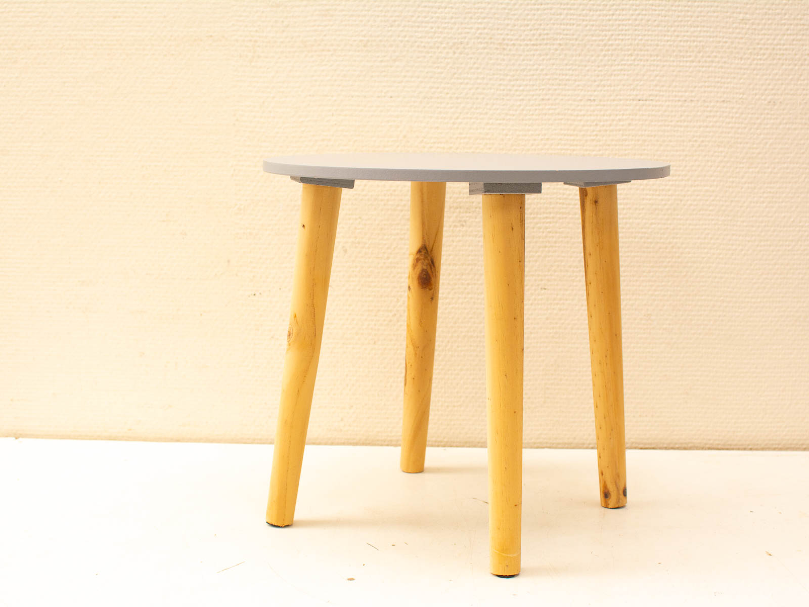 Modern gray round table with wooden tapered legs for stylish and versatile interiors.