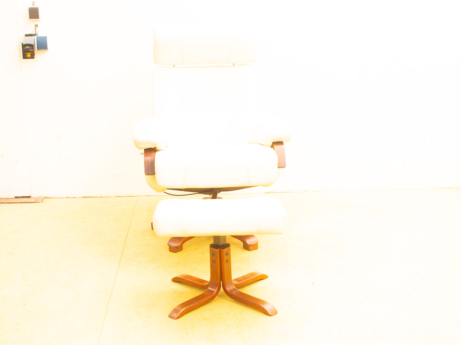 Sleek white lounge chair and ottoman with dark wood accents for modern elegance and comfort.