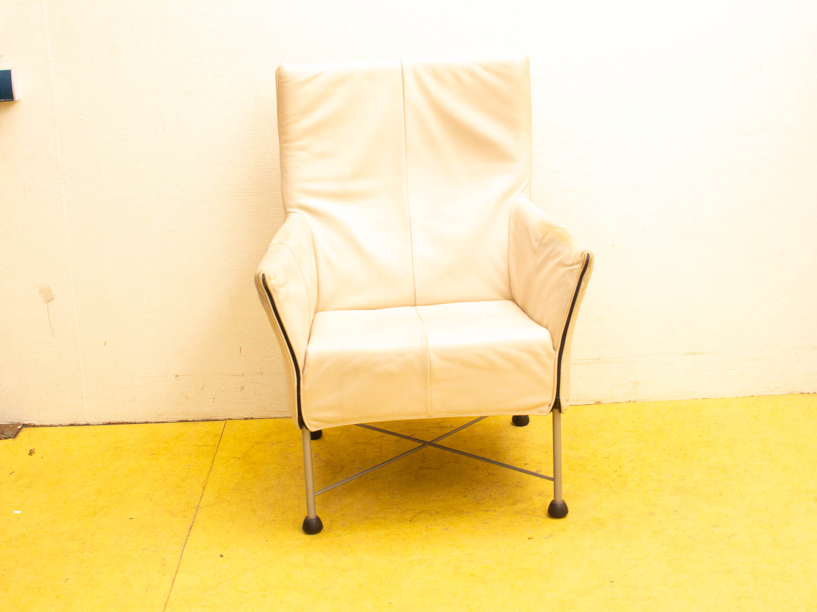 Sleek cream leather chair with geometric design, perfect for modern minimalist interiors.