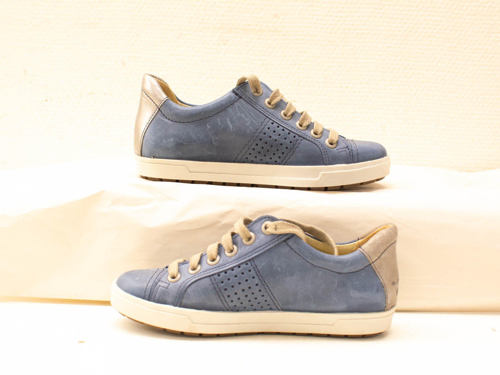 Stylish blue leather sneakers with minimalist design, featuring breathable perforations and durable rubber sole.