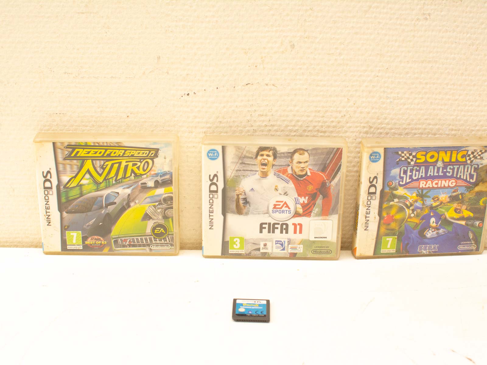 Vintage Nintendo DS game cartridges: Need for Speed, FIFA 11, and Sonic Racing collection.