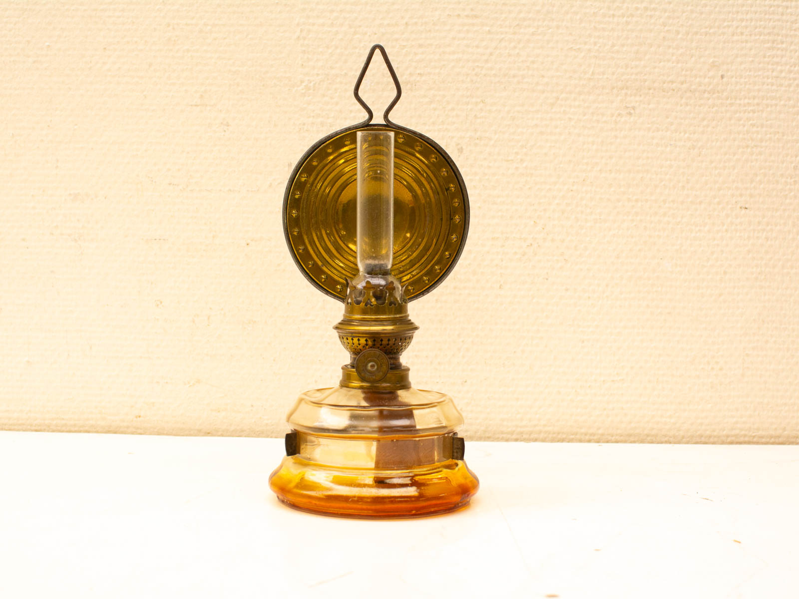 Charming vintage amber oil lamp with metal burner, perfect for adding warmth and nostalgia.