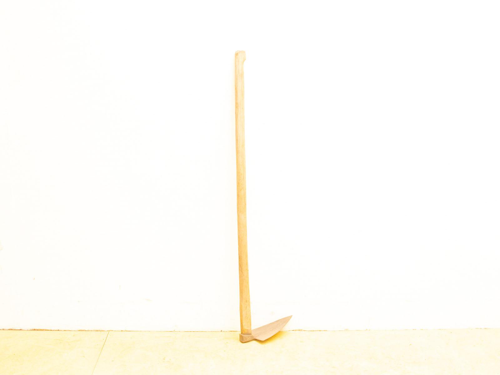 Vintage wooden hoe with a metal blade, perfect for gardening and cultivating soil.