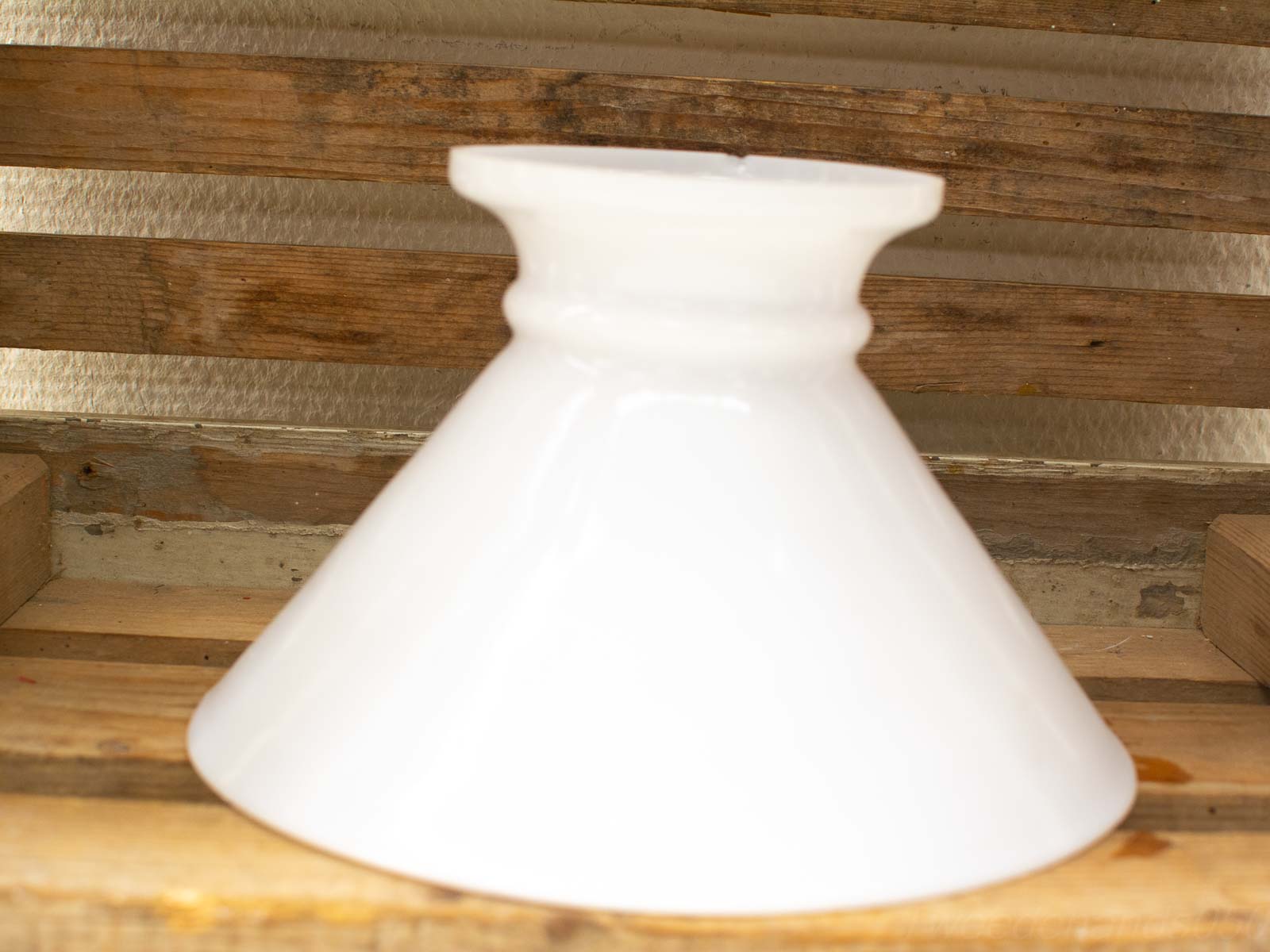 Glossy white ceramic funnel against rustic wood, blending modern elegance with traditional charm.