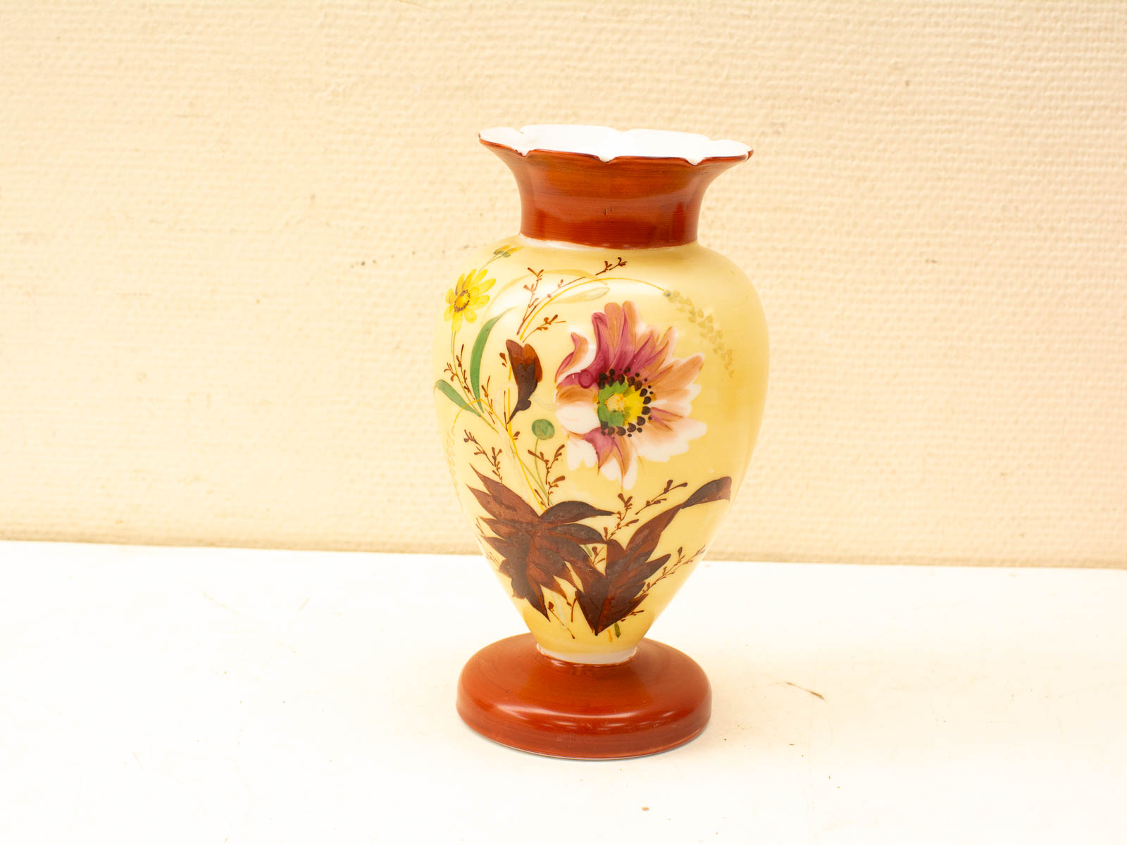 Elegant vintage vase with pink flowers and earthy tones, enhancing any space with charm.