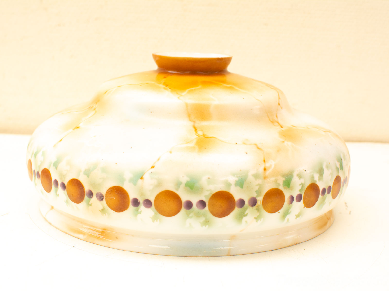 Vintage ceramic bowl with orange and green patterns, showcasing artisanal craftsmanship and charm.