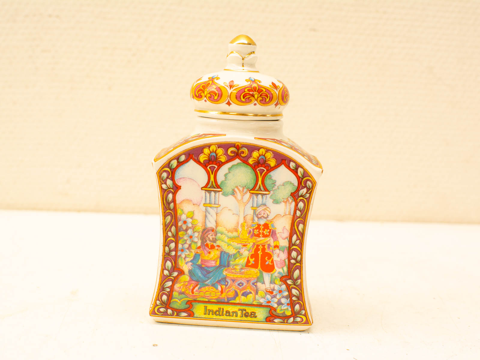 Ornate Indian tea container with vibrant artwork and Mughal-inspired designs showcasing cultural heritage.