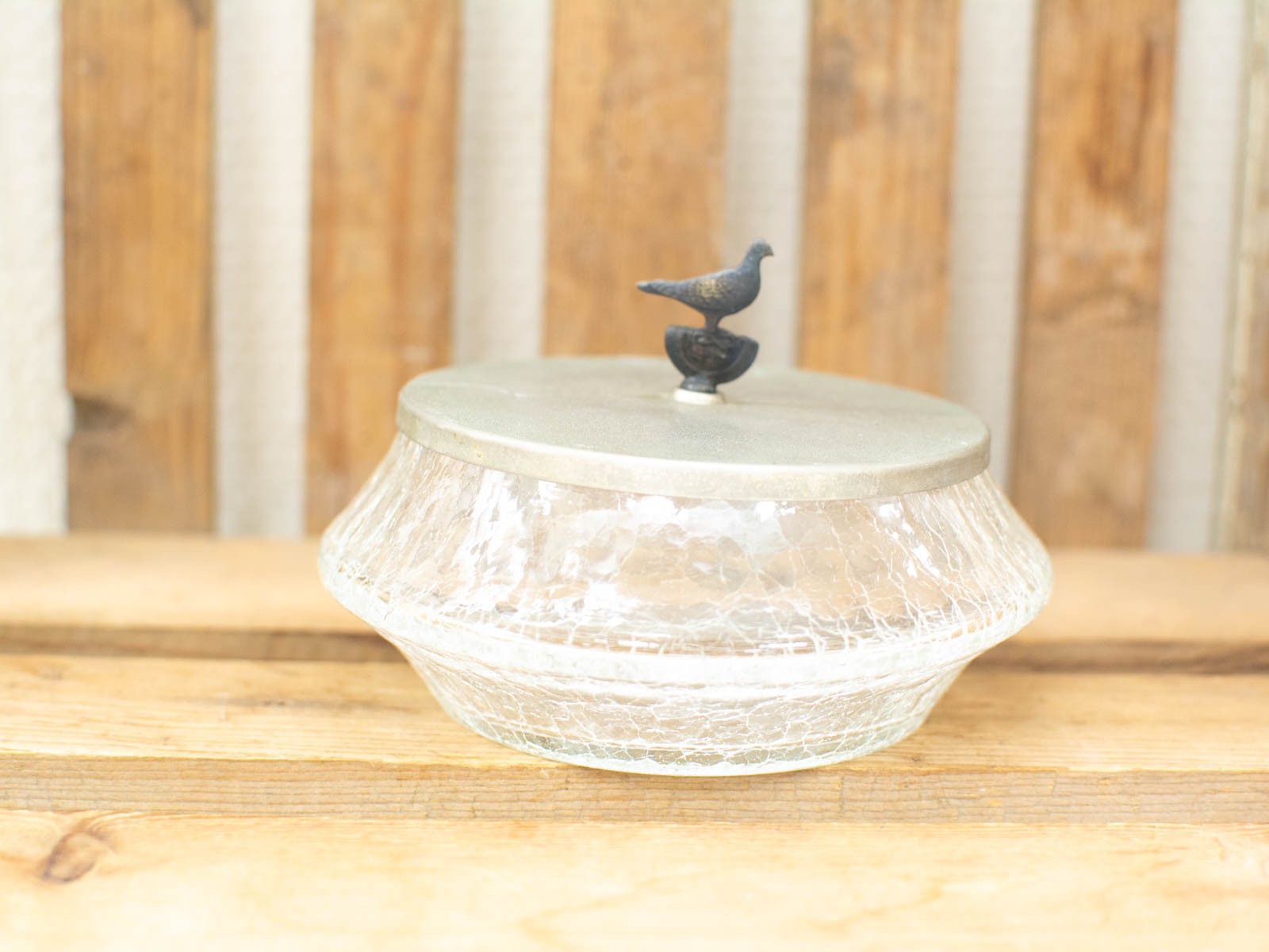 Elegant vintage glass container with a charming bird lid, perfect for decor and storage.