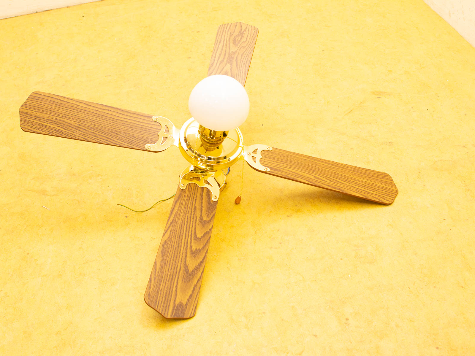 Elegant vintage ceiling fan with wooden blades and glass lighting for charming home decor.