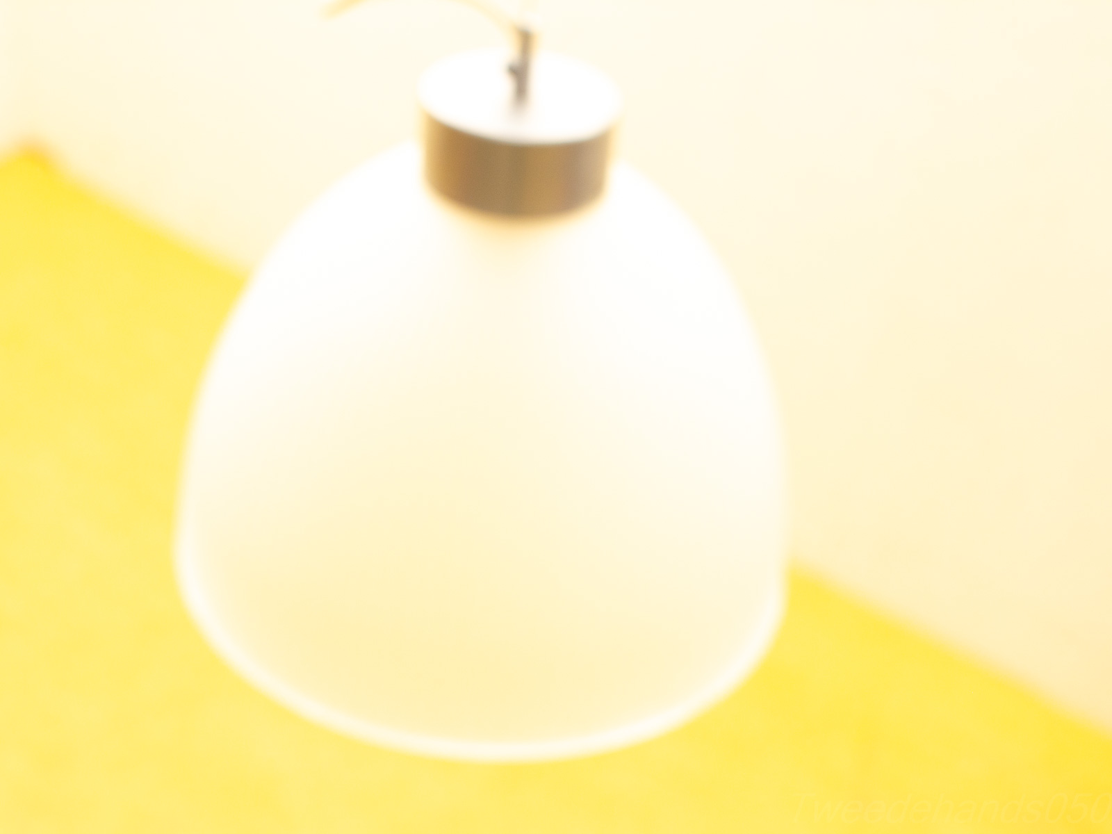 Elegant white dome pendant lamp against a vibrant yellow background, perfect for modern interiors.