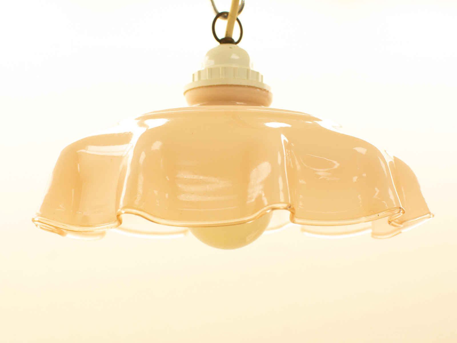 Peach pendant lamp with scalloped edges, adding warmth and charm to any interior space.