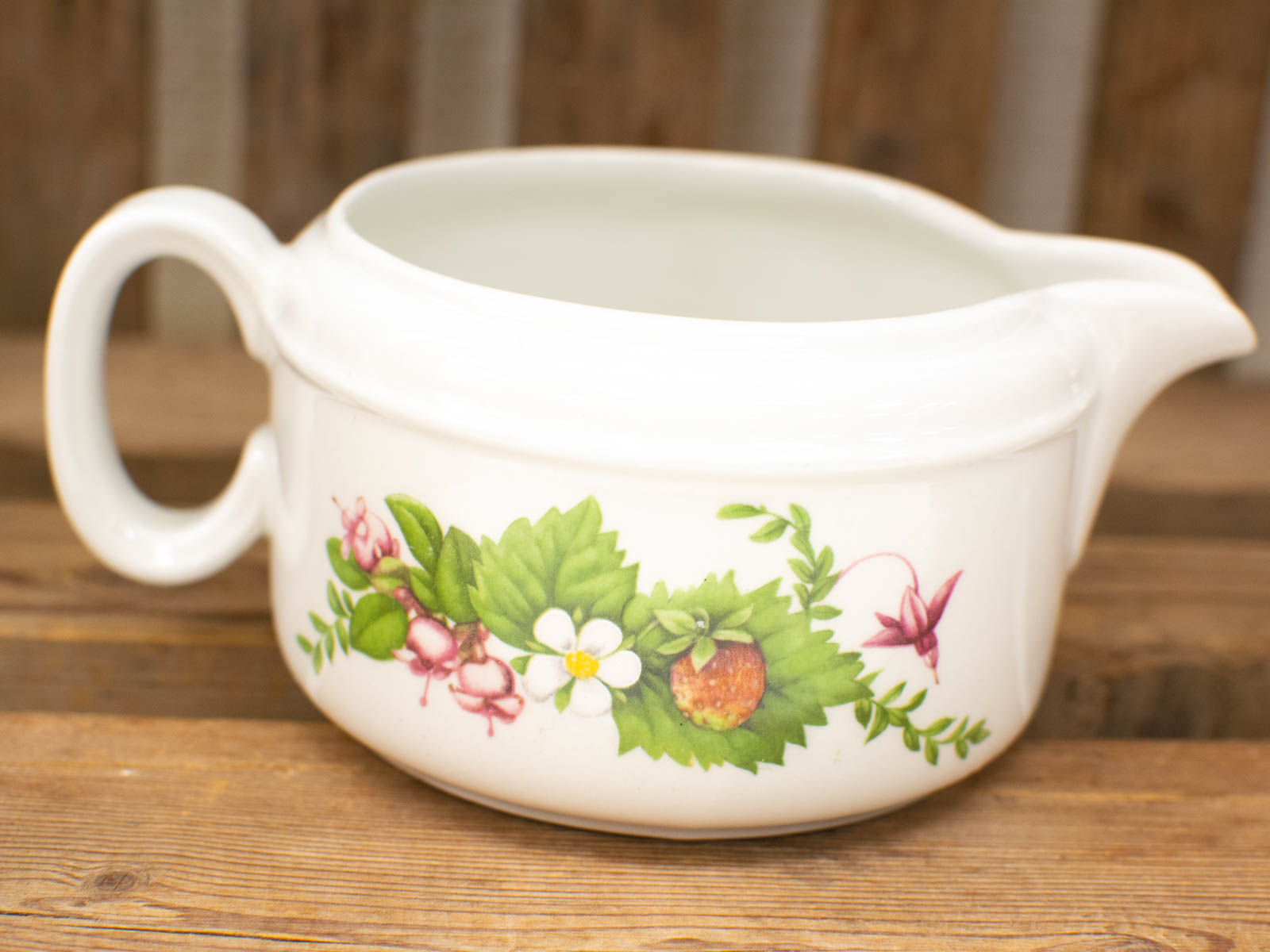 Elegant porcelain creamer with floral design, perfect for serving cream in style.