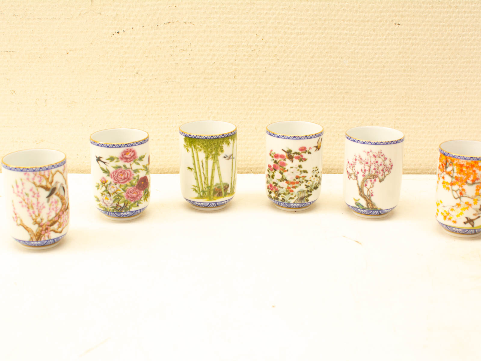 Elegant vintage porcelain cups with unique floral designs, perfect for display and collection.