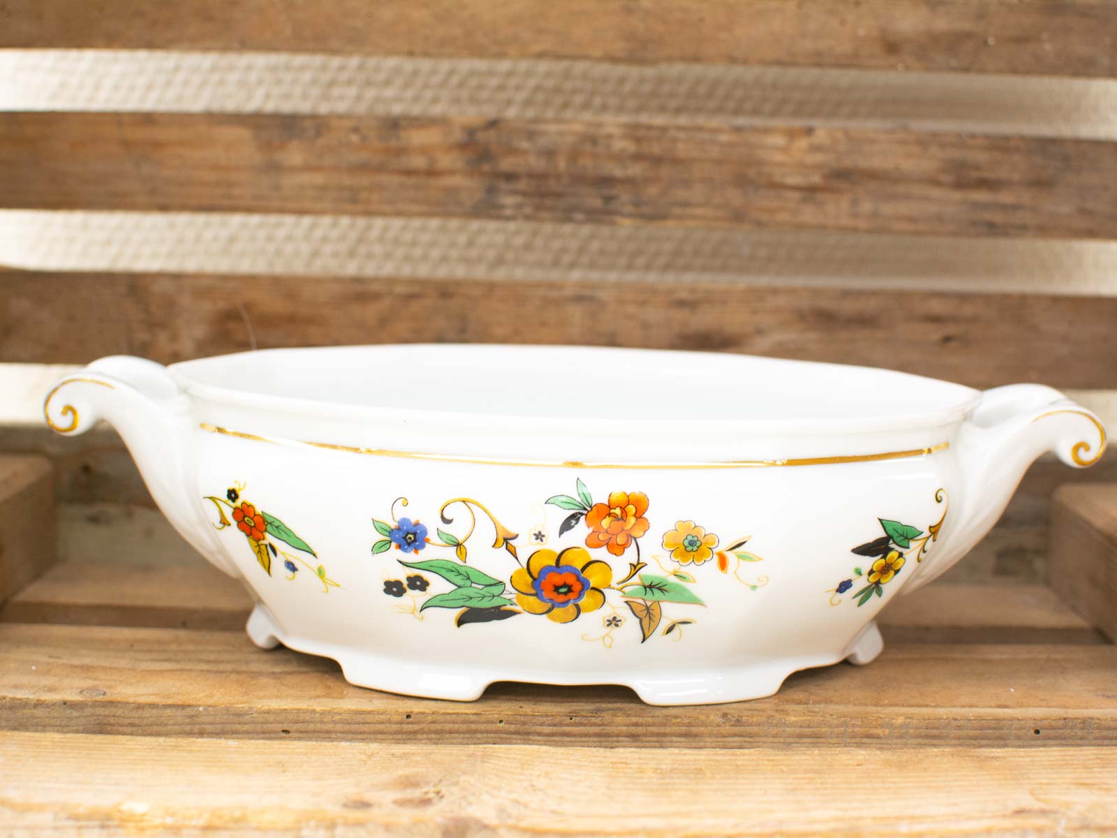 Elegant porcelain serving dish with vibrant floral design and gold rim for sophisticated dining.