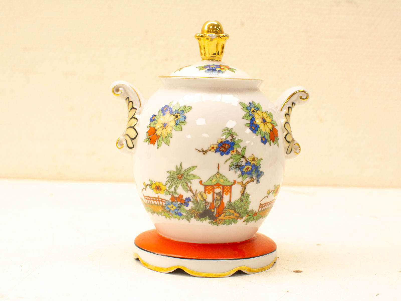 Elegant porcelain teapot with vibrant floral patterns and gold accents, perfect for tea or display.