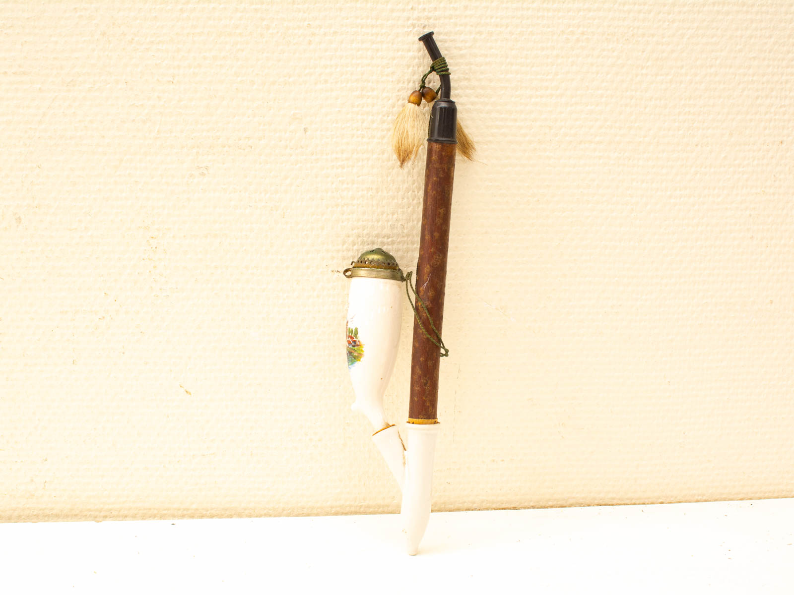 Elegant porcelain stylus and wooden pen with tassels, combining artistry and functionality.