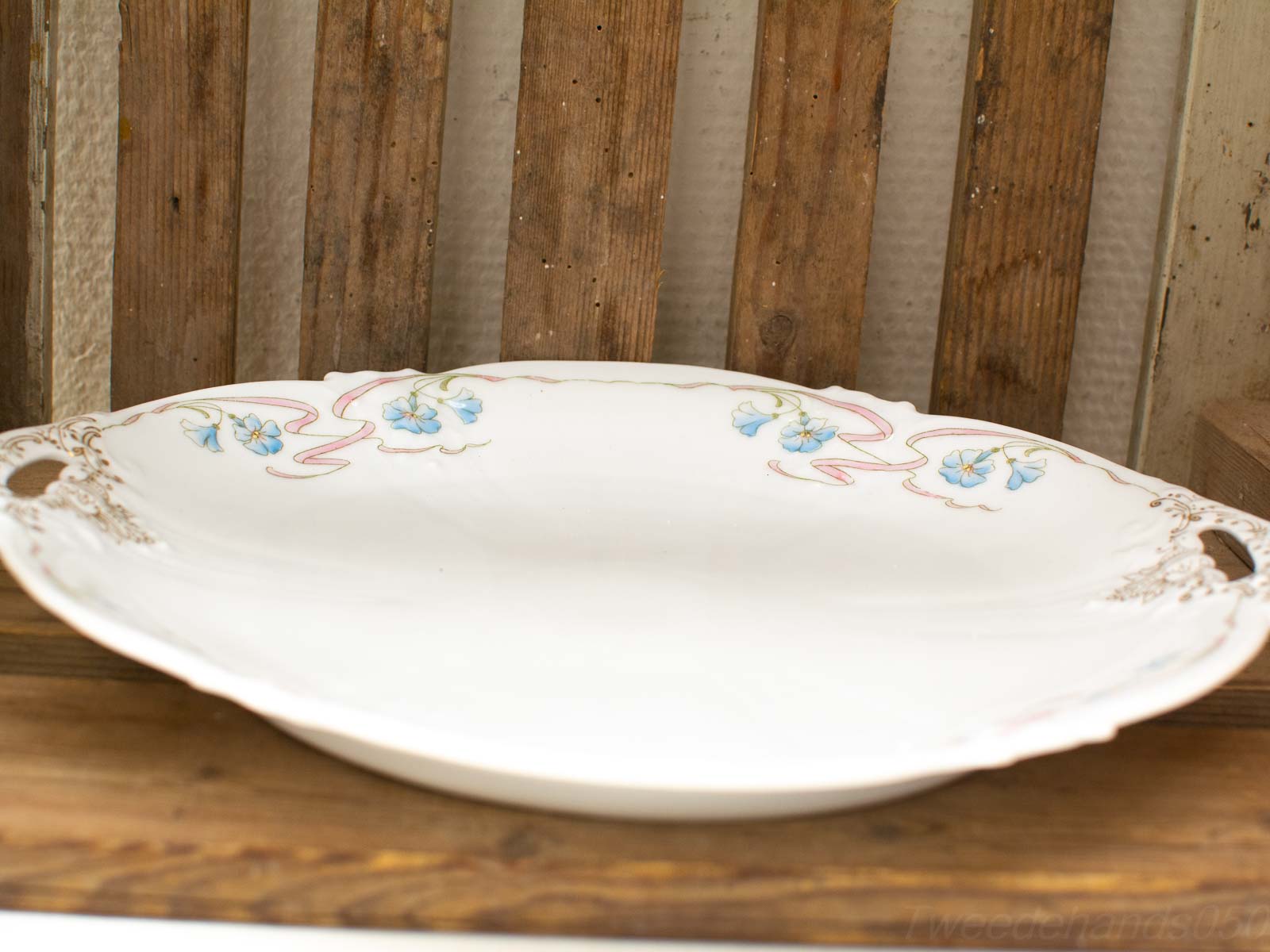 Elegant vintage porcelain platter with delicate blue and pink floral designs, perfect for serving.