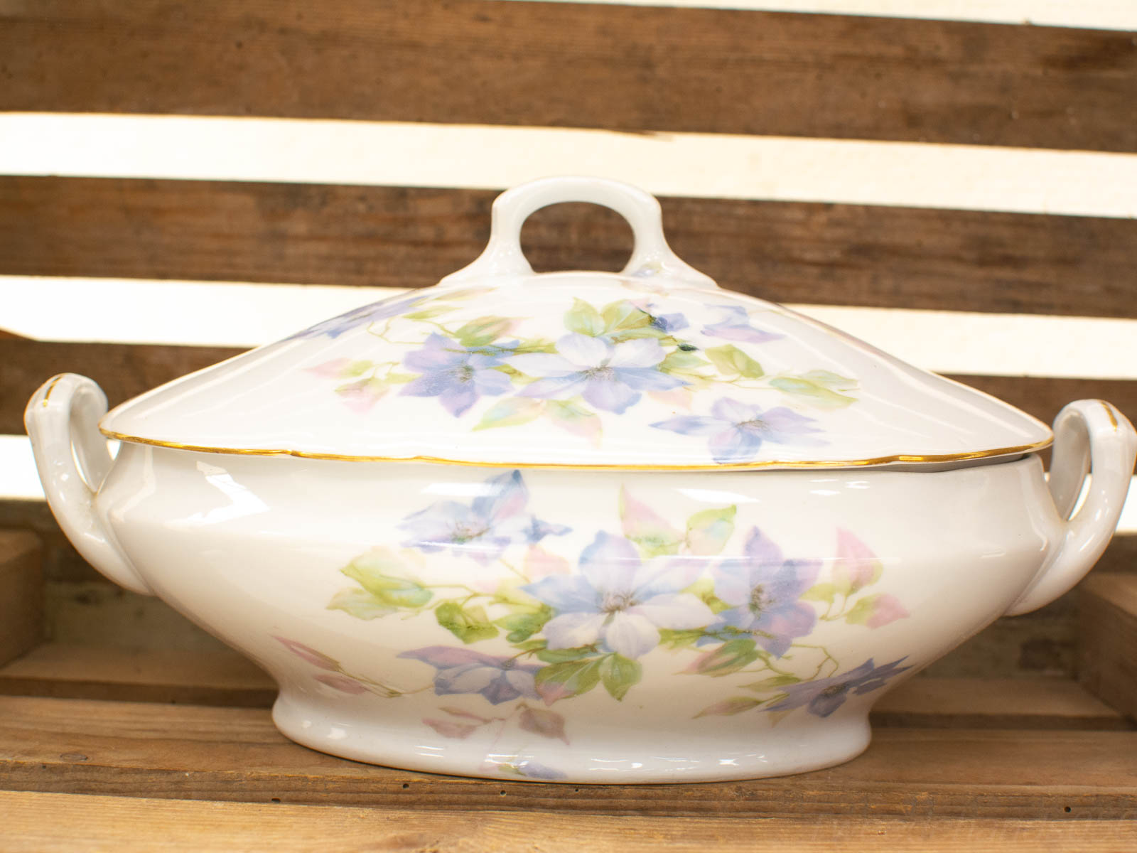 Elegant porcelain tureen with floral designs and gold trim, perfect for serving or decoration.